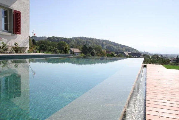 Schöner Überlauf eines Swimmingpools welcher mit Naturstein gebaut wurde