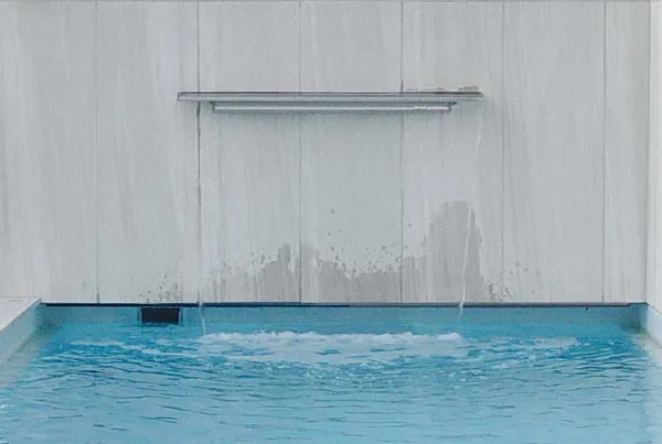 Swimmingpool mit schönem Wasserfall aus der Mauer