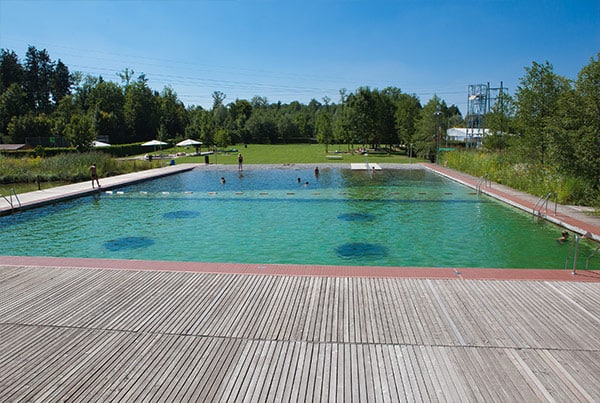 Naturbad als oeffentlicher Schwimmteich Milandia im Sommer